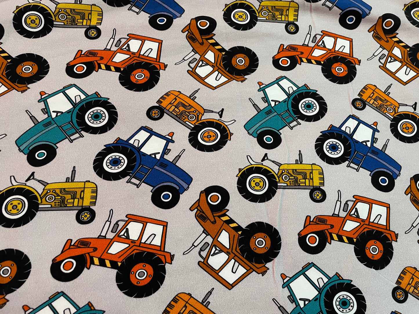 Multicoloured tractors on grey